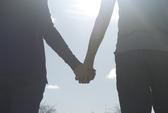 a couple holding hands walking into the sunlight