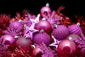 Festive party background of assorted pink Christmas decorations in a random pile for your seasonal greetings