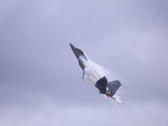 During an air show at high speed the Lockheed Martin F-22 Raptor creates vapor trails from leading flight surfaces