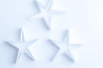 Delicate fragile paper stars on a white background for an ethereal spiritual Christmas background