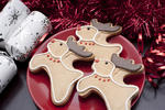 Reindeer Christmas biscuits with chocolate antlers, red noses and collars served on a festive table with crackers and decorations