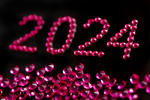 a new years eve party background for 2024 with pink sparkling jewels on a black backdrop